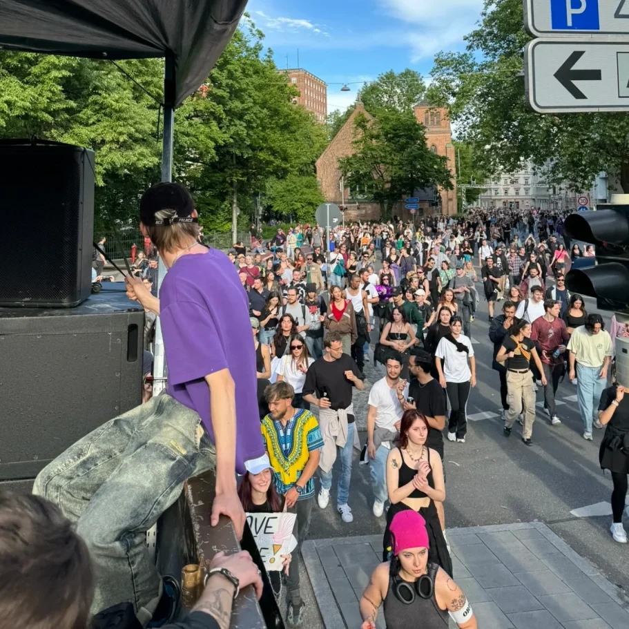 Bunte Menschenmenge auf einer Straße, bei einer Veranstaltung oder Demonstration.